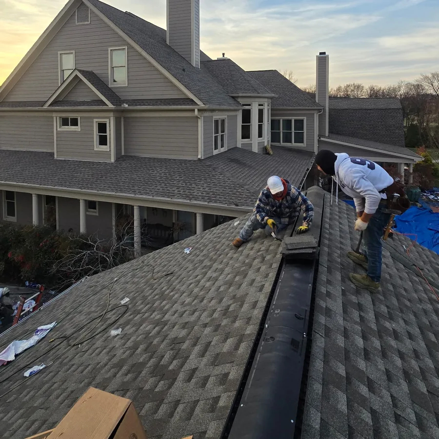Roofing crew installing ridge vent and shingles on a Middle Tennessee home
