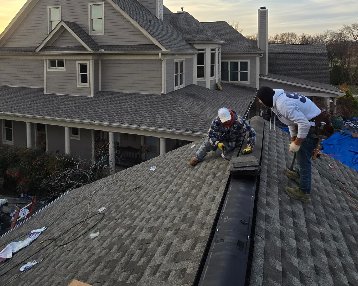 Roofing crew installing ridge vent and shingles on a Middle Tennessee home